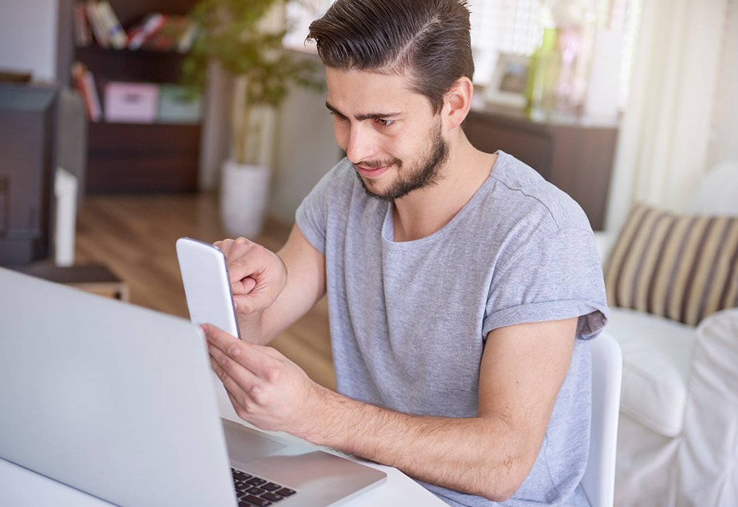 Man met telefoon en laptop