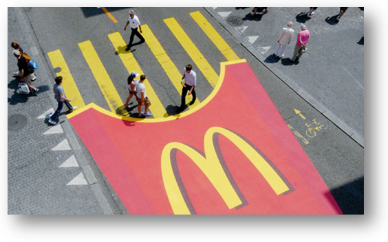 Een afbeelding van een zebrapad waarvan de strepen frietjes moeten voorstellen. Een voorbeeld van guerillamarketing van McDonalds.